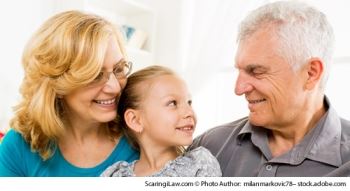 A grandchild sitting in between her grandmother and grandfather.